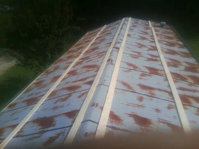 Rusted metal roof panels with new wood purlins before replacement — Storm Damage Roof Repair in Paulina by Roofing Brothers