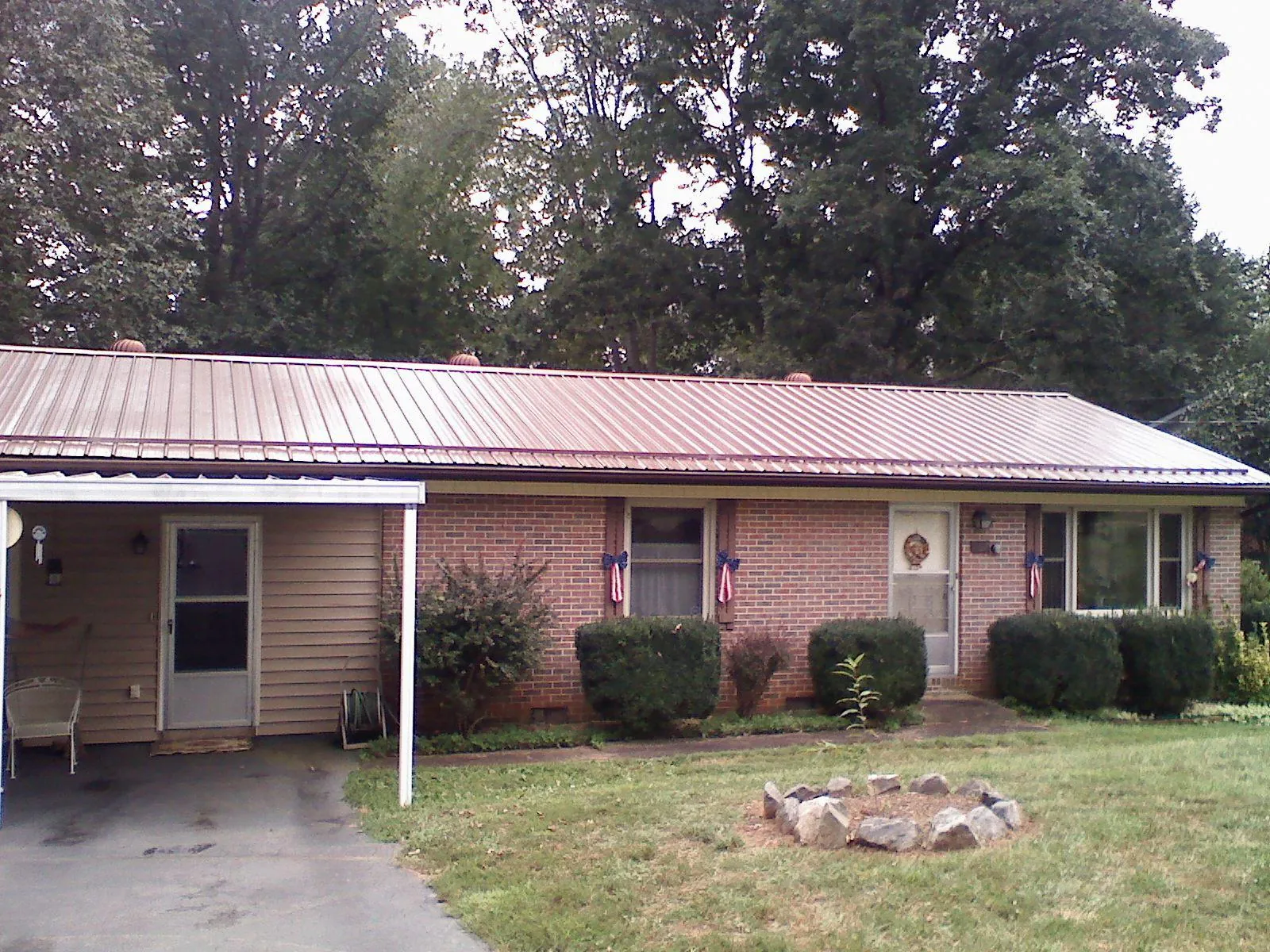 Bronze metal roof and carport on a brick ranch home — Roof Repair work by our crew in Paulina
